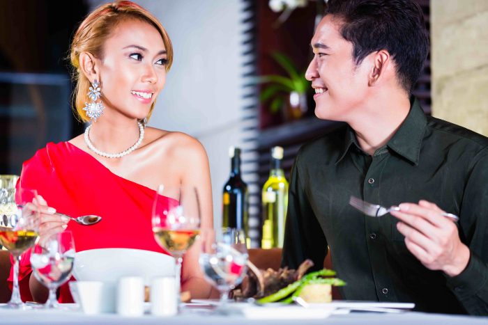 Asian couple fine dining in fancy restaurant