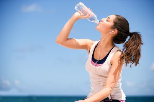 young teenager drinking water after exercise.